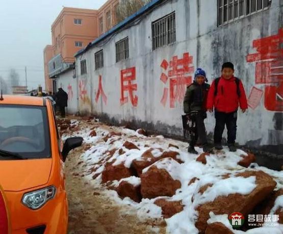 前去上学的孩子走在湿滑的道路上